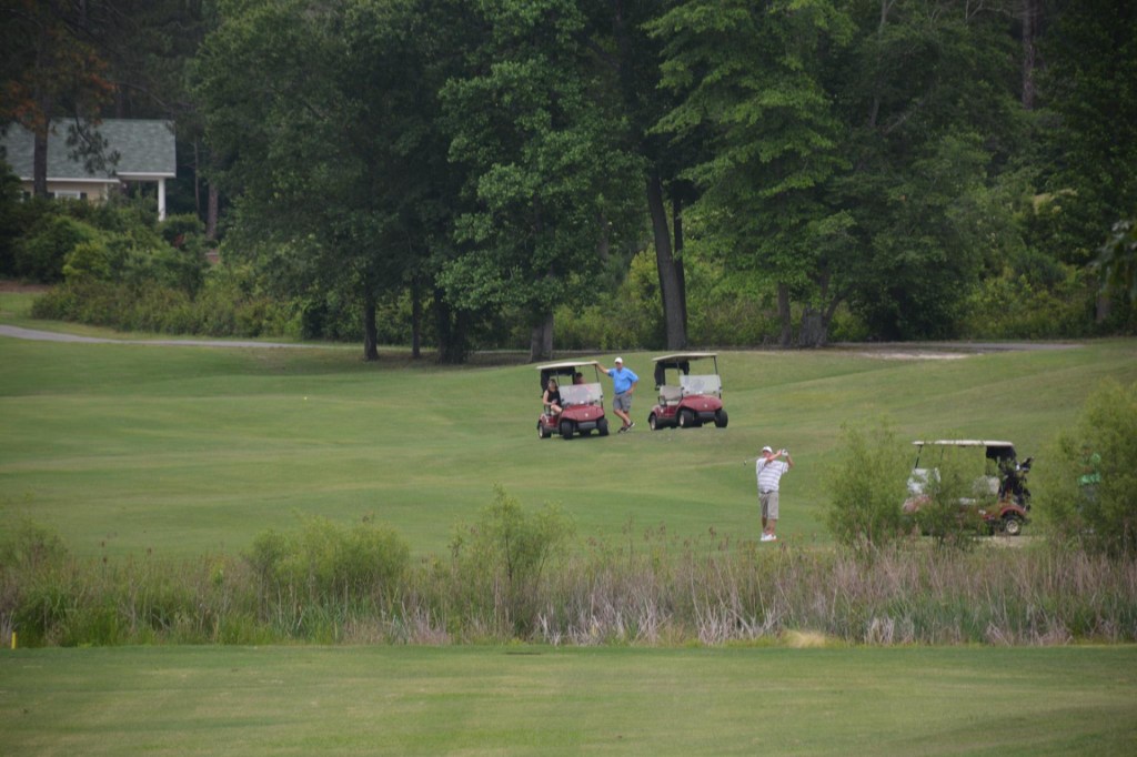 golfers with golf carts on fairway